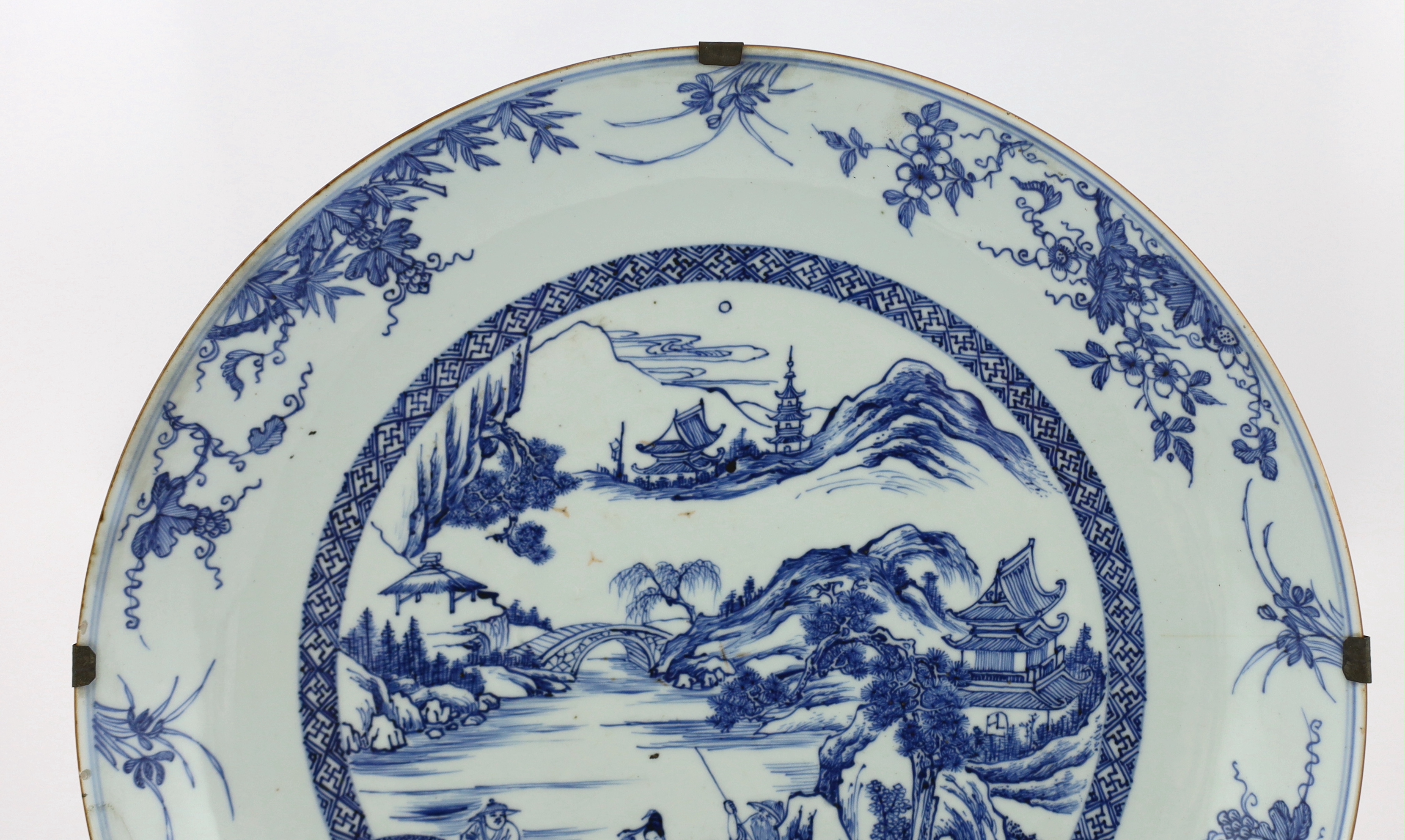 A Chinese blue and white landscape dish, Yongzheng/Qianlong period, short hairline crack